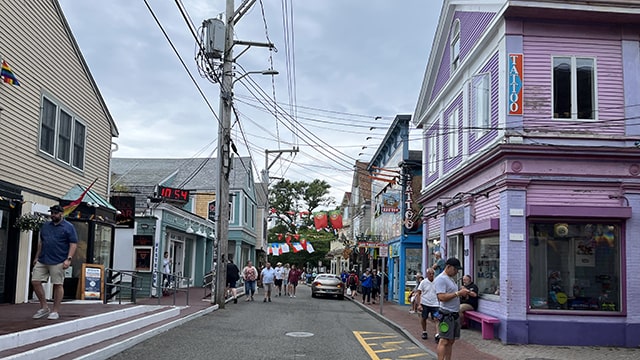 people in the street crowd in front of colorful buildings