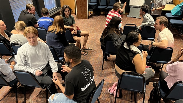 young people sitting in small groups in a carpeted room