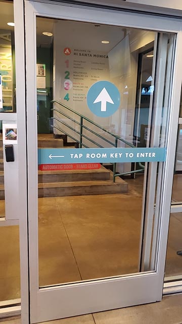 Locked doors secure access to HI Los Angeles Santa Monica hostel with keycard access-only entry