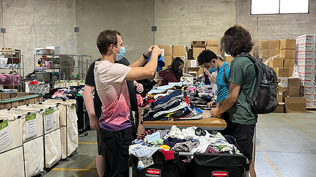 volunteers sort clothing in a warehouse