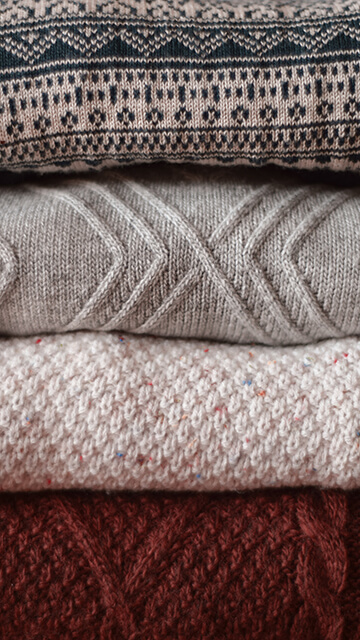 a stack of thick multi-colored sweaters