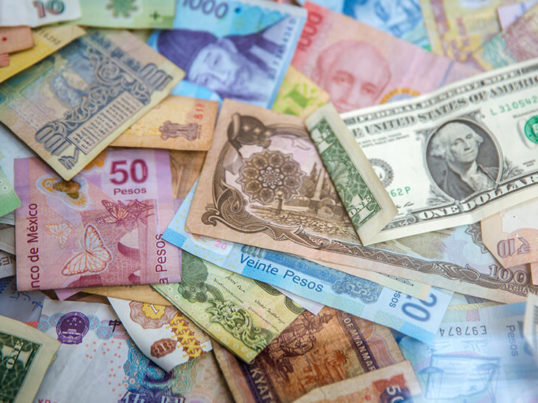 a variety of colorful currency from around the world