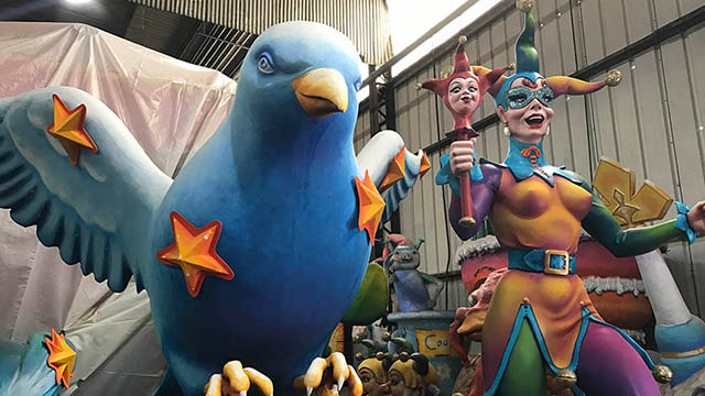 a large plaster blue bird with yellow stars and a colorful jester
