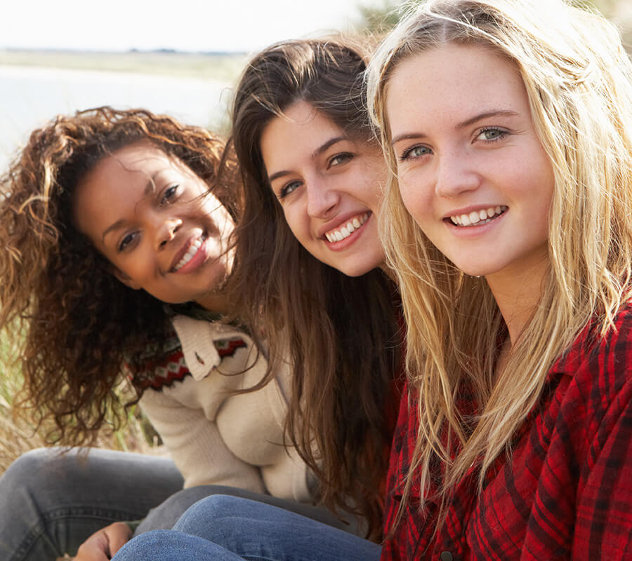 three young women sit side by side