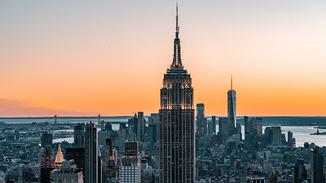 a skyscraper with the sunset in the background