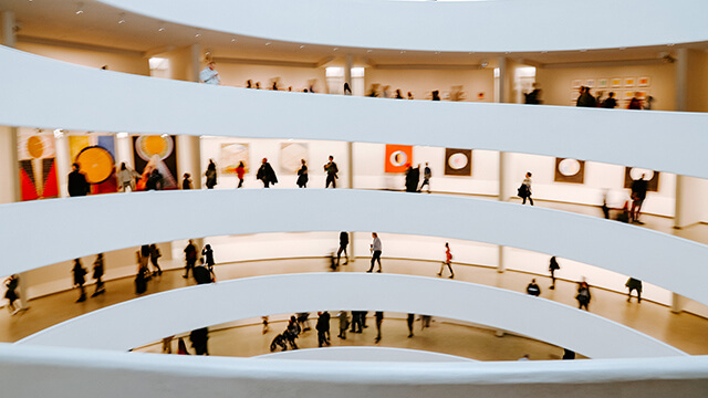 an interior view of several levels of a circular building with people walking