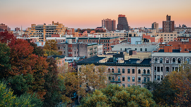 a sunset over rooftops in Harlem, New York City