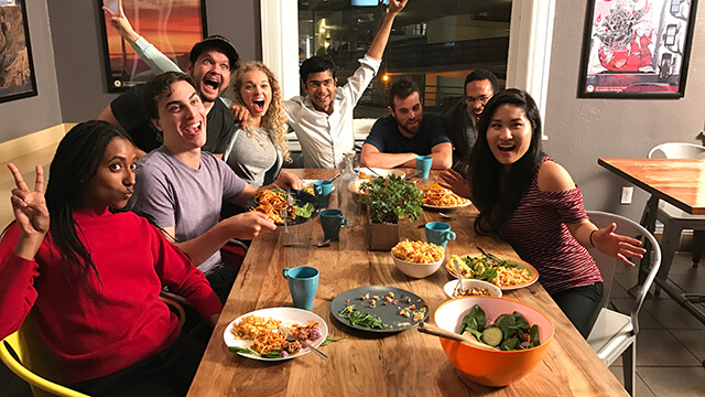 a group of people sit around a table covered with plates of different kinds of food