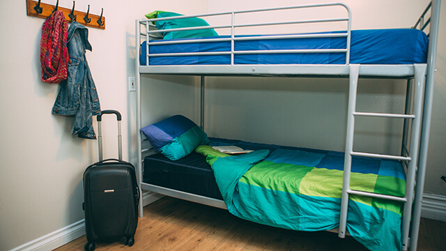 a locked suitcase in a small hostel dorm room