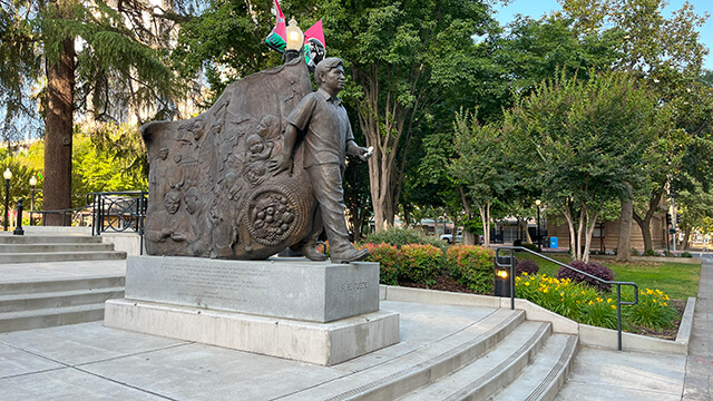 a statue of Cesar Chavez stands at the entrance to Cesar Chavez plaza in Sacramento CA