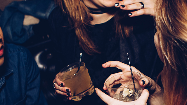 two friends clink glasses