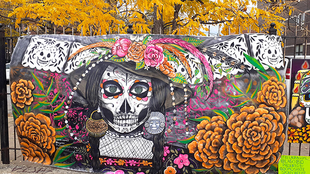 a colorful mural for Dia de los Muertos is surrounded by yellow fall foliage at the National Museum of Mexican Art in Chicago