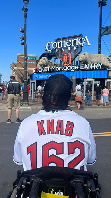 Peter Knab, who attended all 162 Cleveland Guardians baseball games in 2023, sits in his wheelchair outside the Tigers' baseball stadium in Detroit