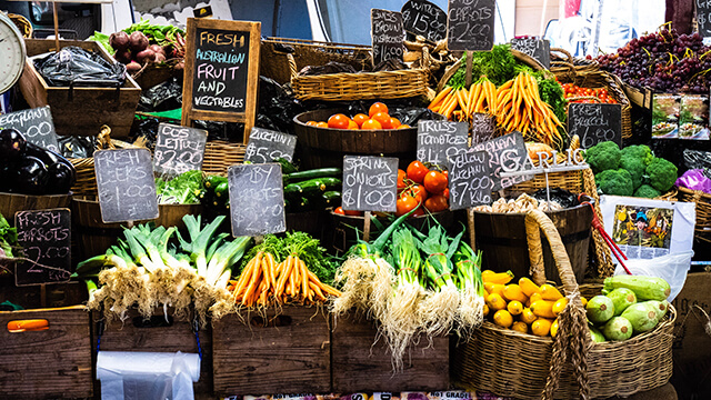 rows of colorful fruits and vegetables at an outdoor market