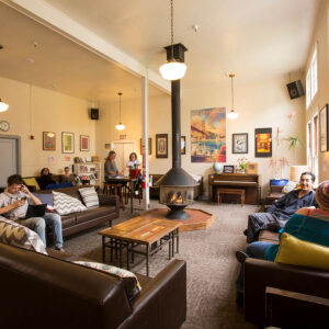 Guests relax around the fireplace in the cozy guest lounge at HI San Francisco Fisherman's Wharf hostel