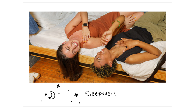 two young friends lie on their backs on a bunk bed laughing