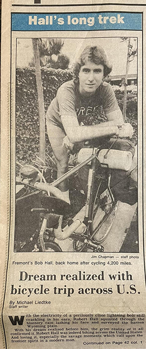 an old newspaper clipping with a black and white image of a young man and his bicycle. The article is about the man completing a cross-country bicycling trip with AYH.
