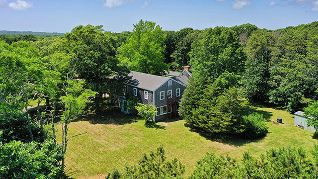 The exterior of HI Martha's Vineyard hostel today, as seen surrounded by lawn and forest