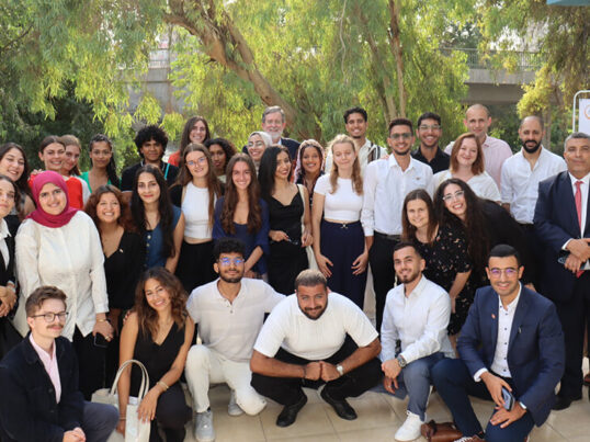 A large group of young people from around the world, participating in HI USA's IOU Respect program in Egypt, pose for a group photo.