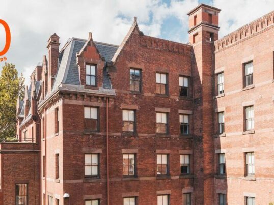 The Richard Morris Hunt-designed HI New York City hostel. A very large brick building with slate mansard roof and many windows is seen from the side.