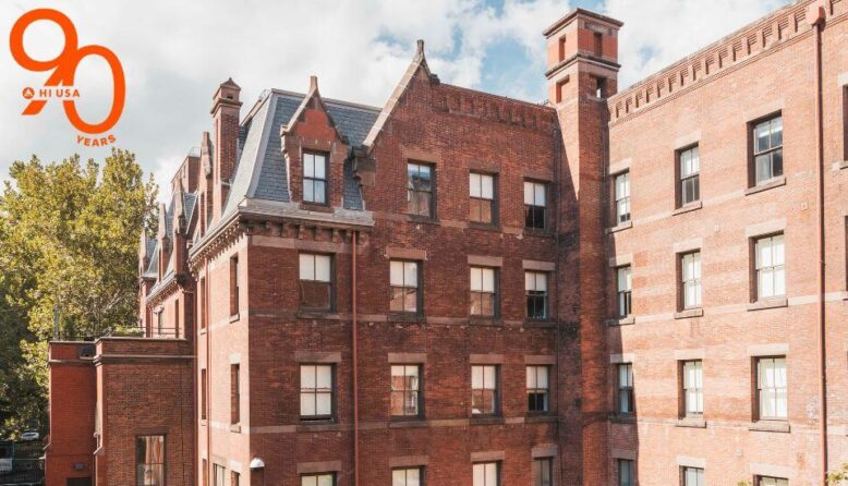The Richard Morris Hunt-designed HI New York City hostel. A very large brick building with slate mansard roof and many windows is seen from the side.