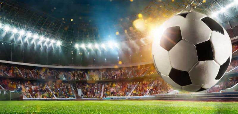 a soccer ball in a brightly lit football stadium