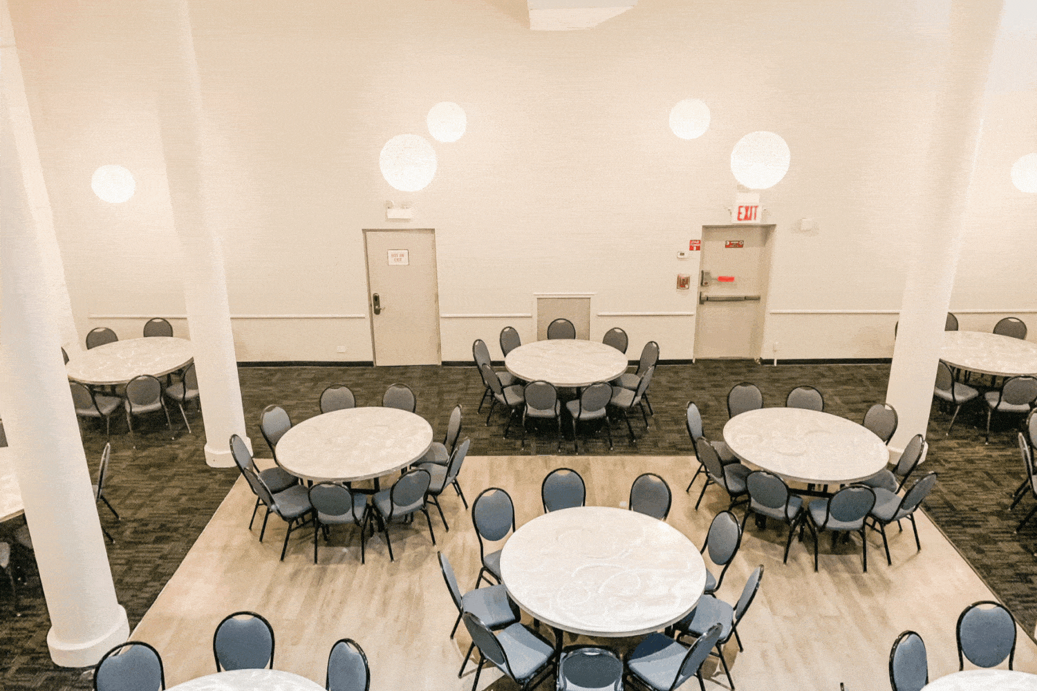 Rotating images of the elegant and spacious SoHo room at HI New York, City. There are plenty of tables and chairs, high ceilings, and wood floors.