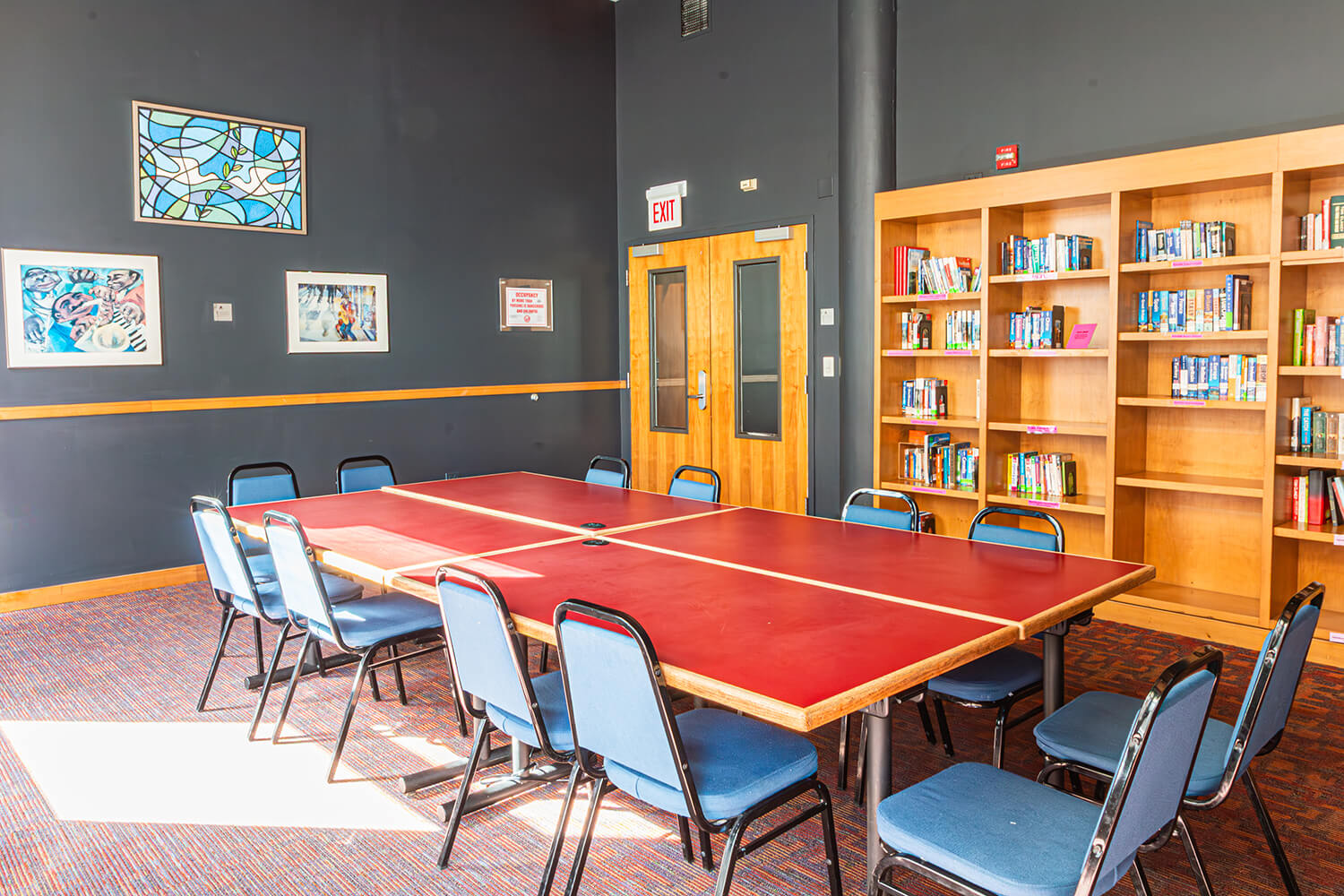 The library at HI Chicago hostel has a large table with chairs, plus wall-mounted bookcases.