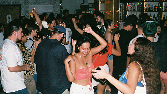 A large group of people dancing inside a bar