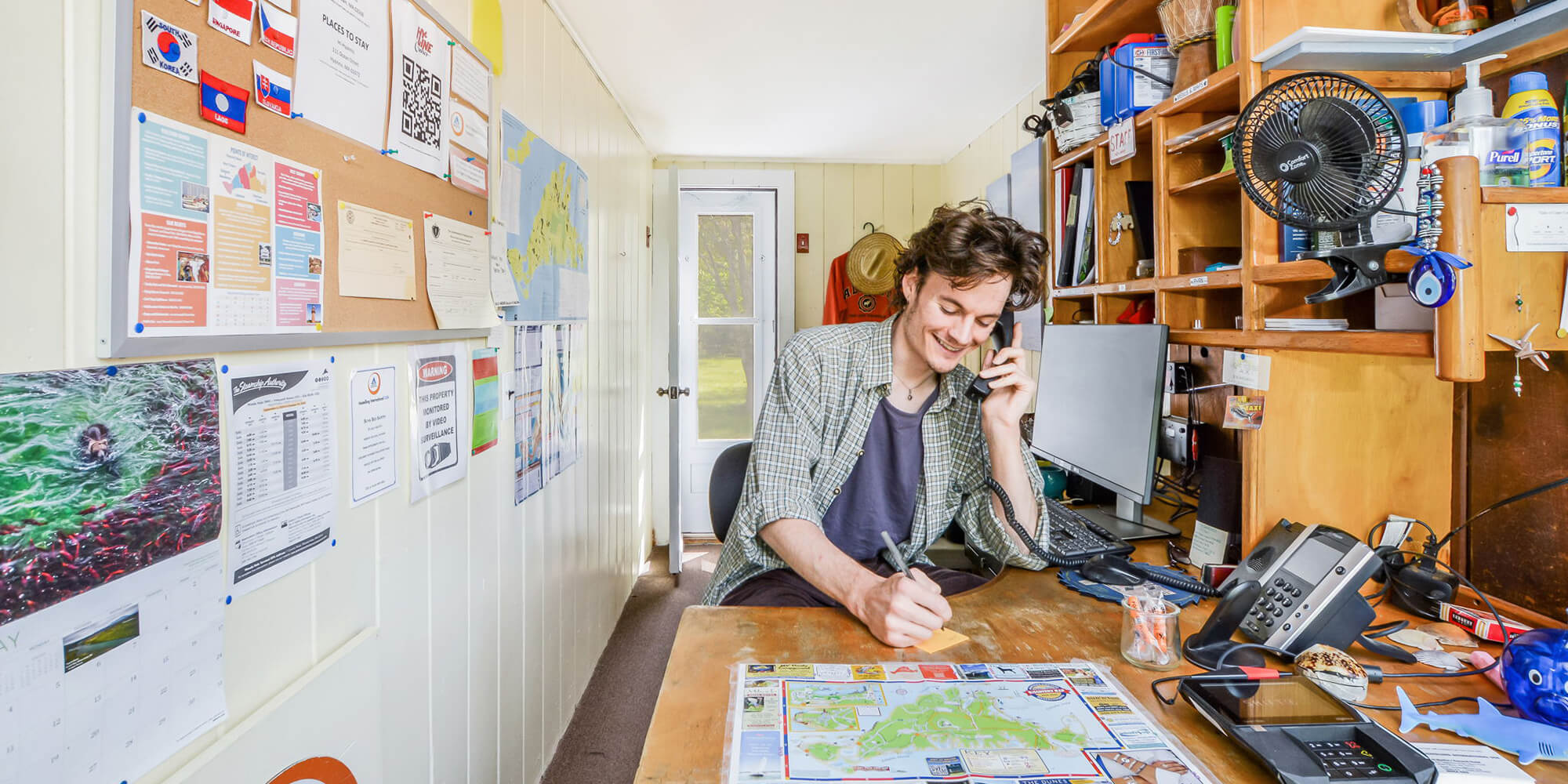 A friendly staff member answers the phone at the front desk of HI Martha's Vineyard hostel