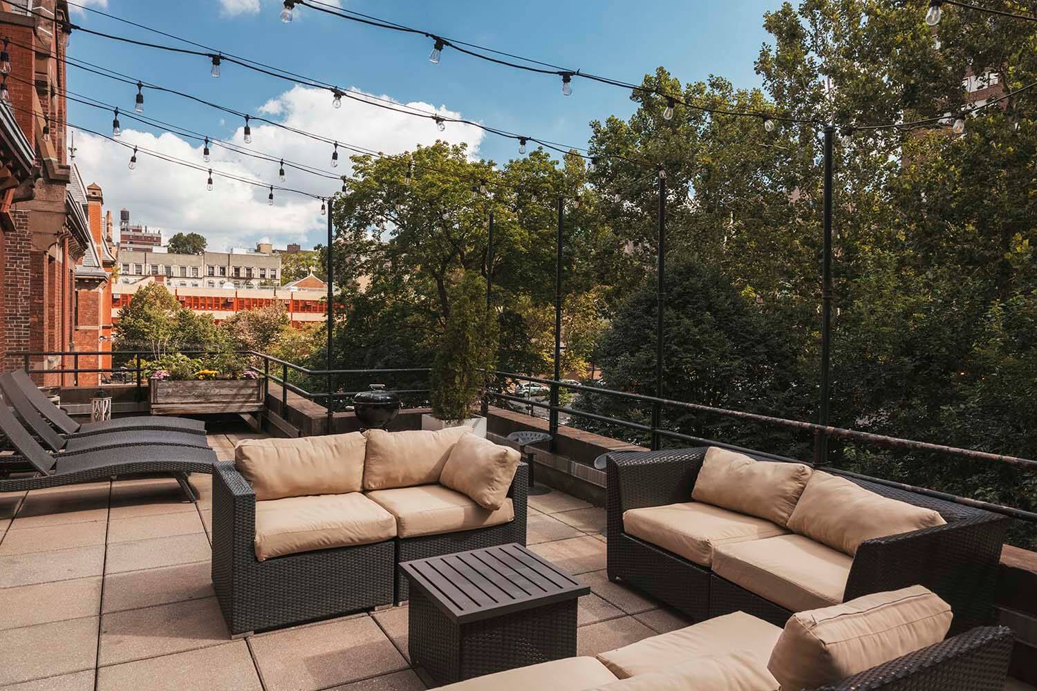 The expansive penthouse terrace at HI New York City hostel comes with lights and ample seating for guests at indoor-outdoor events.
