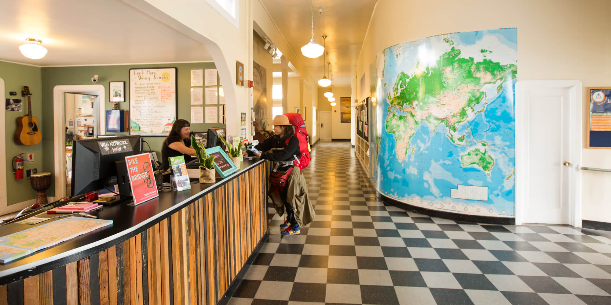 A guest checks in with a friendly front desk agent at HI San Francisco Fisherman's Wharf hostel
