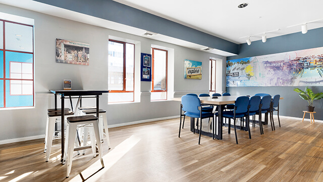 Bright, modern library at HI Los Angeles Santa Monica with a long communal worktable and high-top seating.