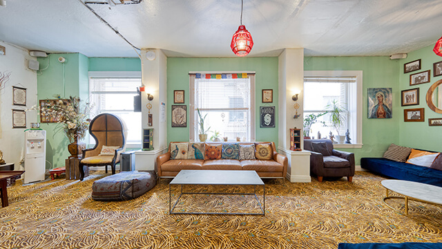 Well-lit guest lounge at HI San Francisco Downtown featuring large windows and comfortable, laptop-friendly areas.