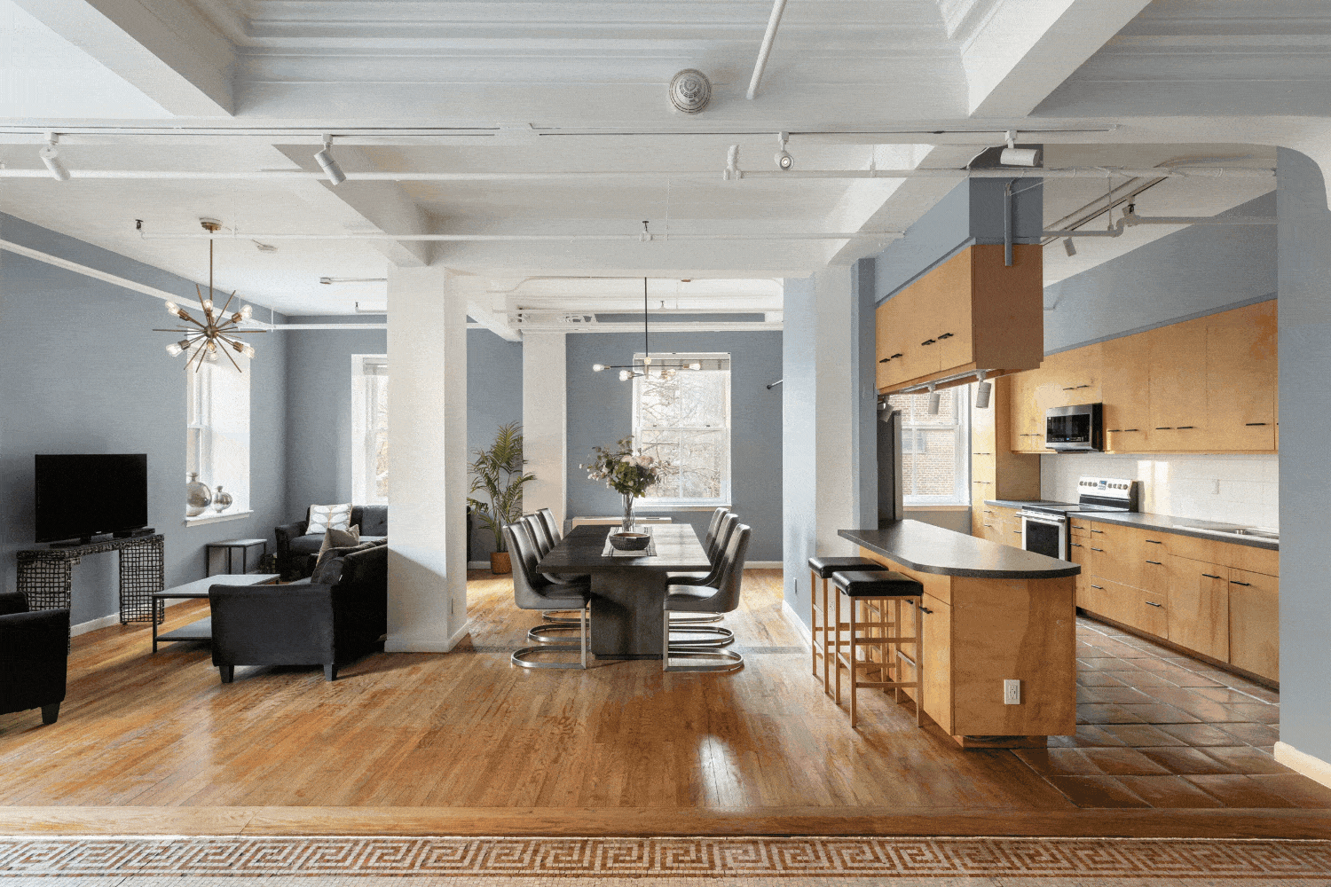 A rotating gif of images of the penthouse at HI New York City hostel, showing its open-concept living space set up for both small and large parties, its fully equipped kitchen, and its expansive private terrace.